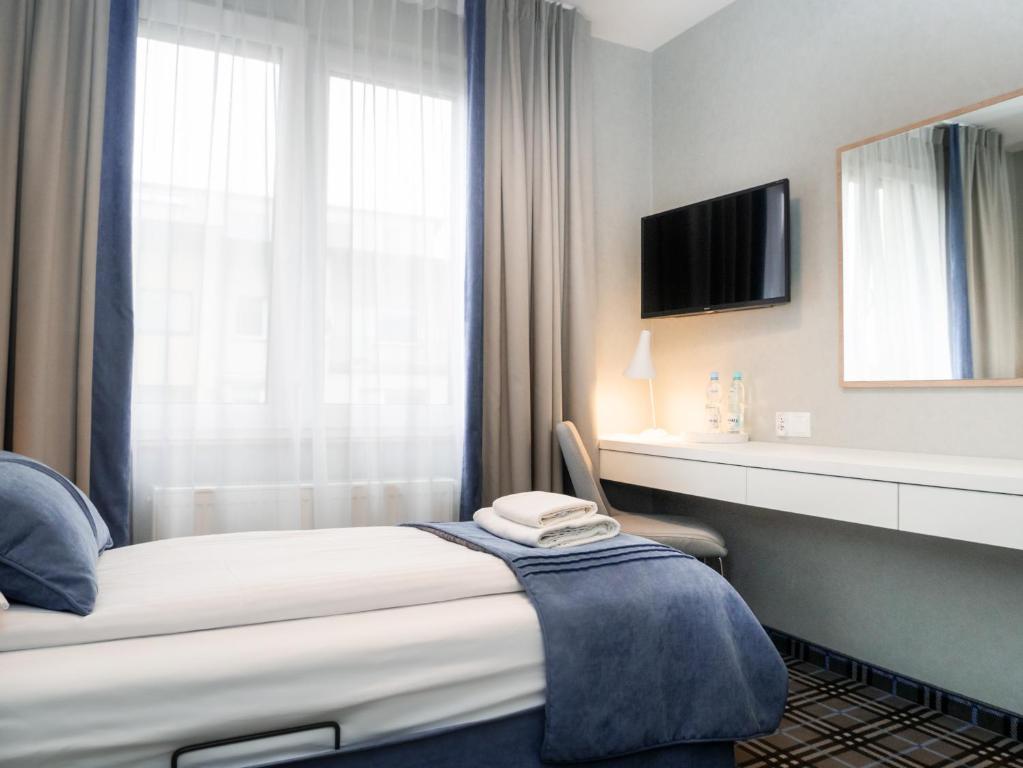 um quarto de hotel com uma cama e uma televisão em Villa Familia em Gdansk