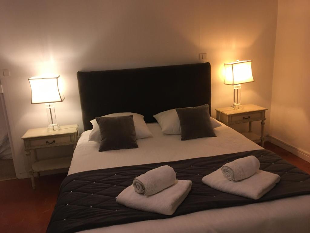 a bedroom with a large bed with two lamps at Auberge De Marie in Bras-dʼAsse