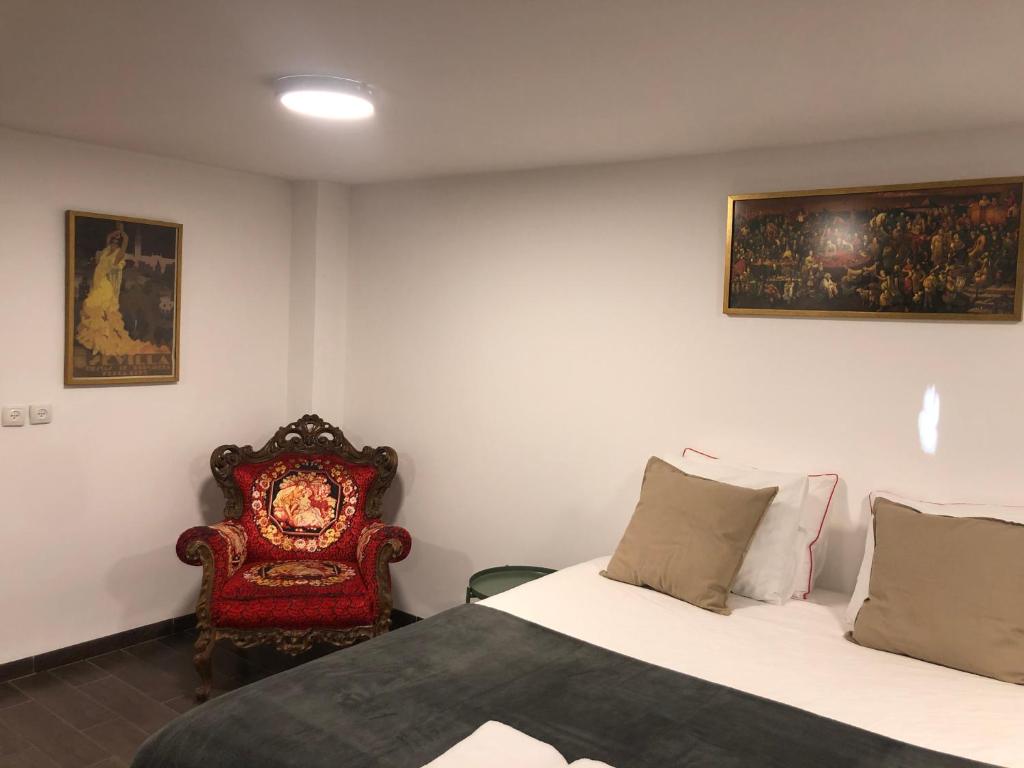 a bedroom with two beds and a red chair at Hassan Guesthouse in Nazareth
