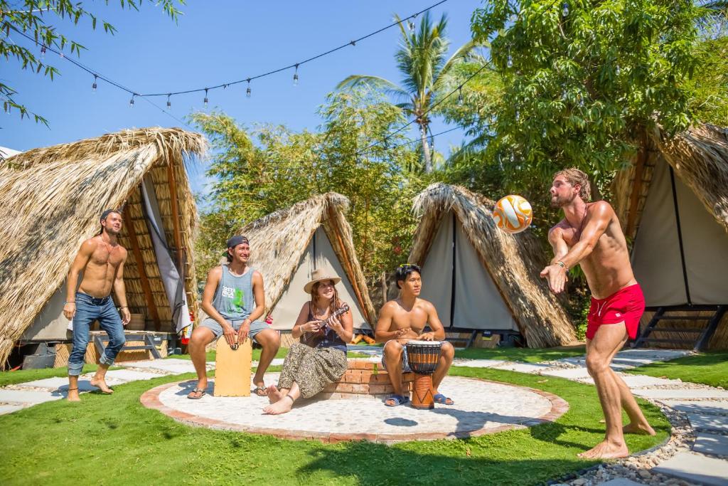 a group of men playing volleyball in front of their lodges at Selina Puerto Escondido in Puerto Escondido