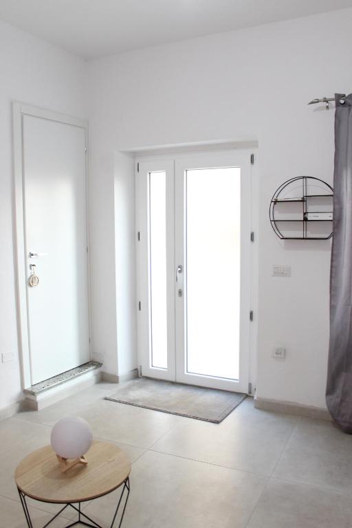 a white room with a table and a door at Tatta & Nanna Apartment in Oliena