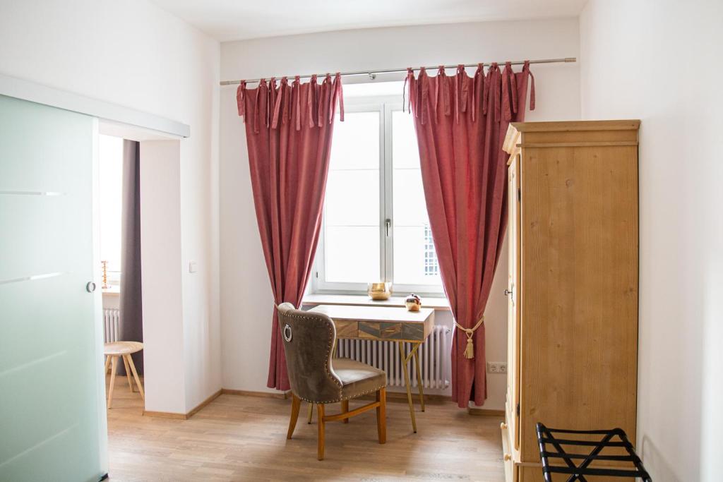 a room with a desk and a window with red curtains at Apartment 6 in Stockach
