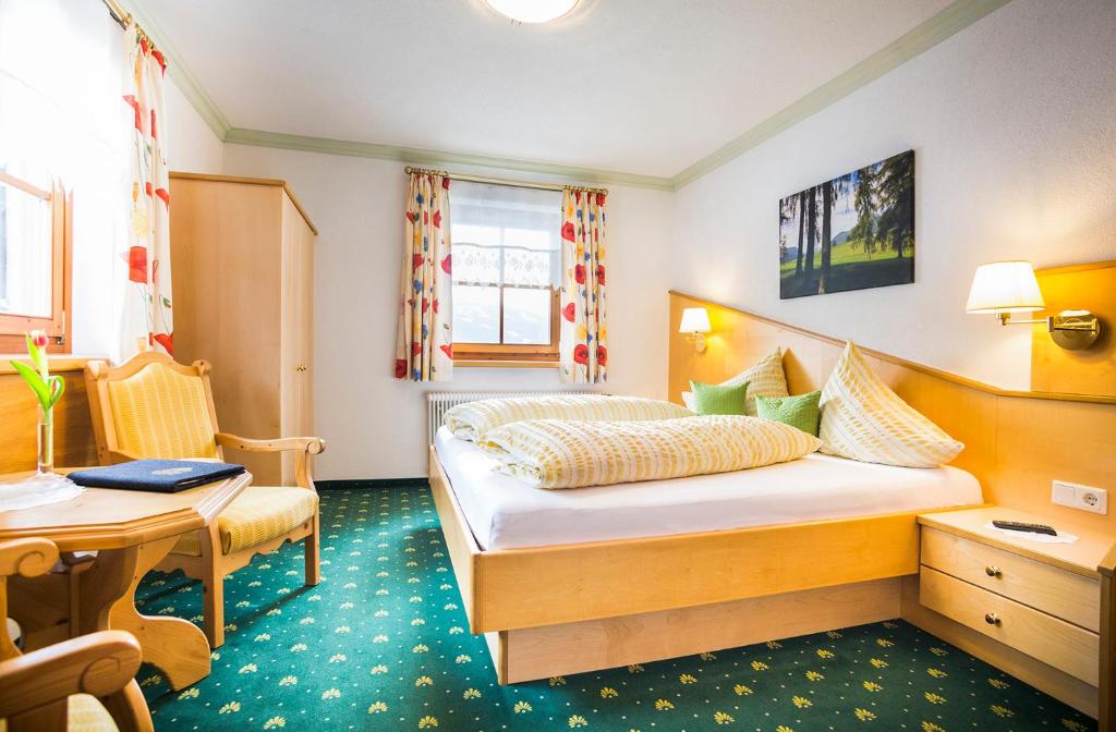 オプシュタイクにあるGästehaus Fitschのベッドとデスクが備わるホテルルームです。