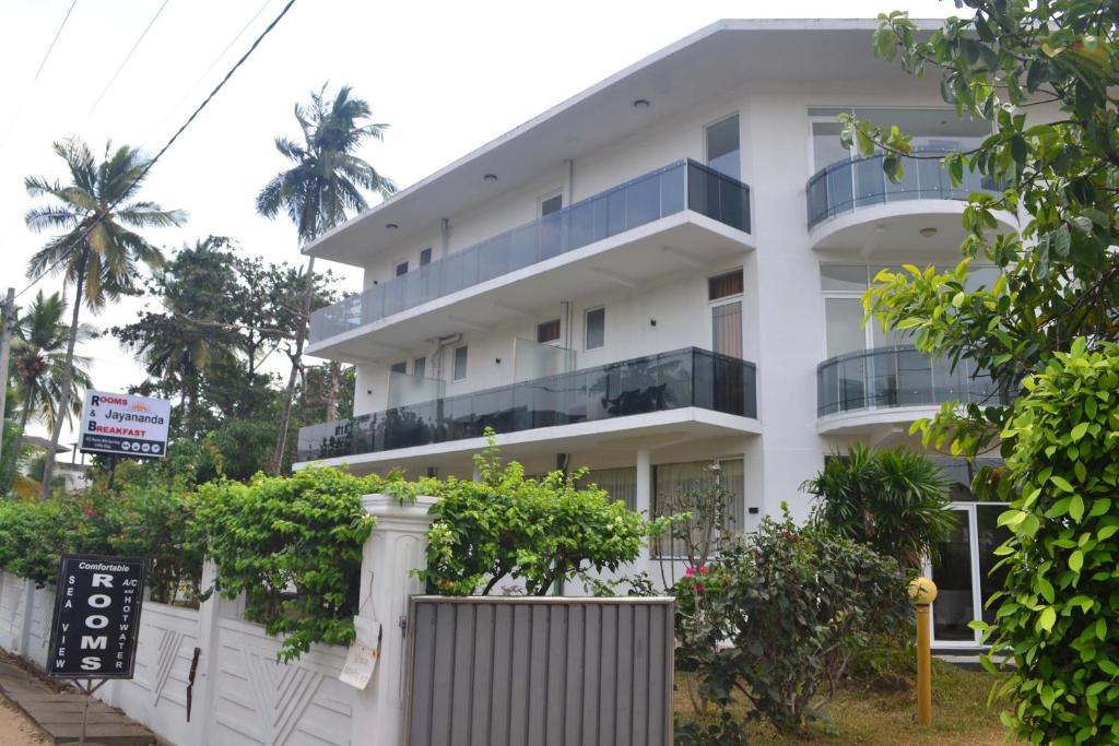 um edifício branco com uma cerca em frente em Villa Jayananda em Dickwella