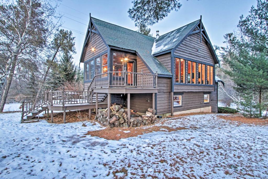 a wooden house with a deck in the snow at Waterfront Arkdale Retreat 2 Acres with Deck and View in Arkdale
