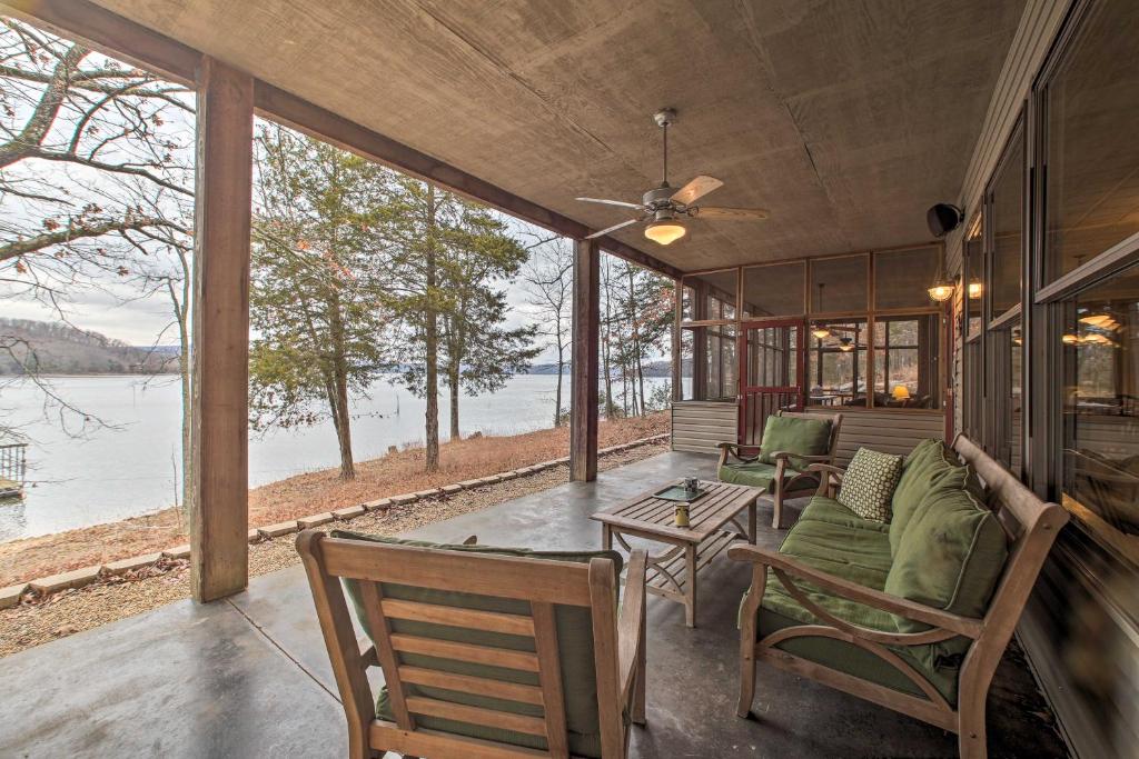 un porche cubierto con sillas y mesa en Family and Fisherman Friendly Home on Beaver Lake!, en Garfield