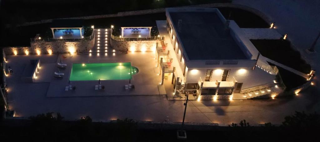 un gran edificio con una gran piscina por la noche en Villa Fumarola, en Ostuni