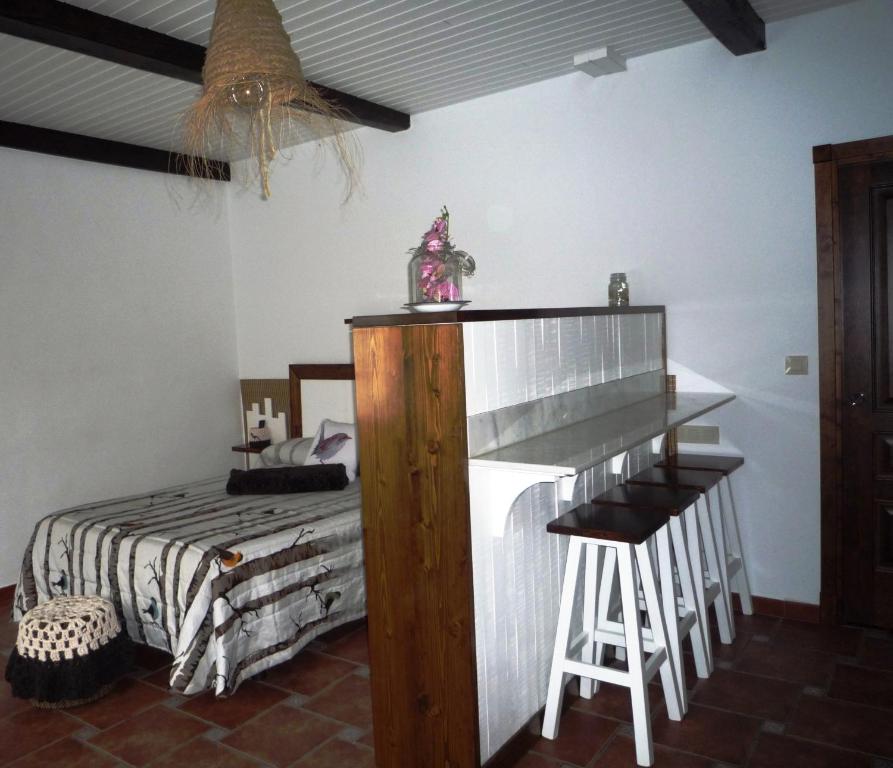 1 dormitorio con 1 cama, mesa y taburete en Casa da Gándara Apartamento en Boimorto