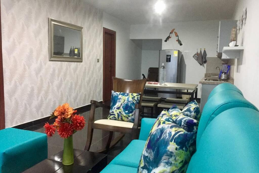 sala de estar con sofá azul y cocina en Apartamento en Coveñas cómodo y acogedor, en Coveñas