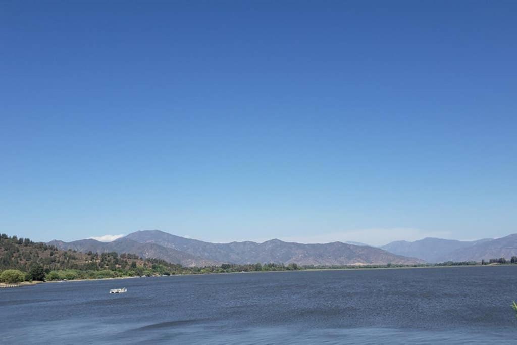 a boat on the water with mountains in the background at Espectacular Departamento Marina Golf Rapel in Las Cabras