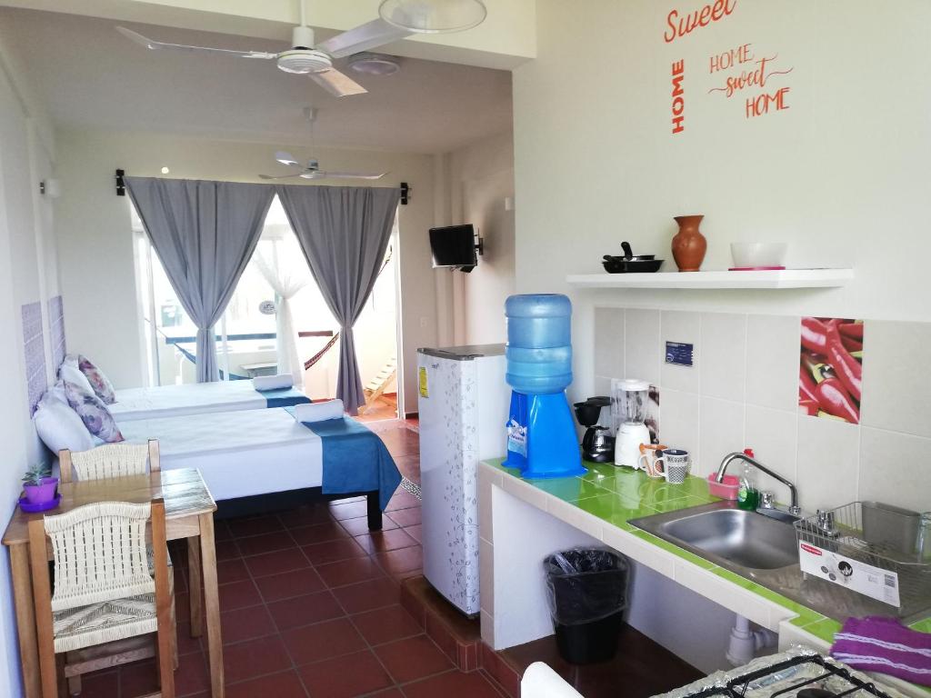 a kitchen with a sink and a bed in a room at Casa Puerto Bonito & Private Coworking in Puerto Escondido