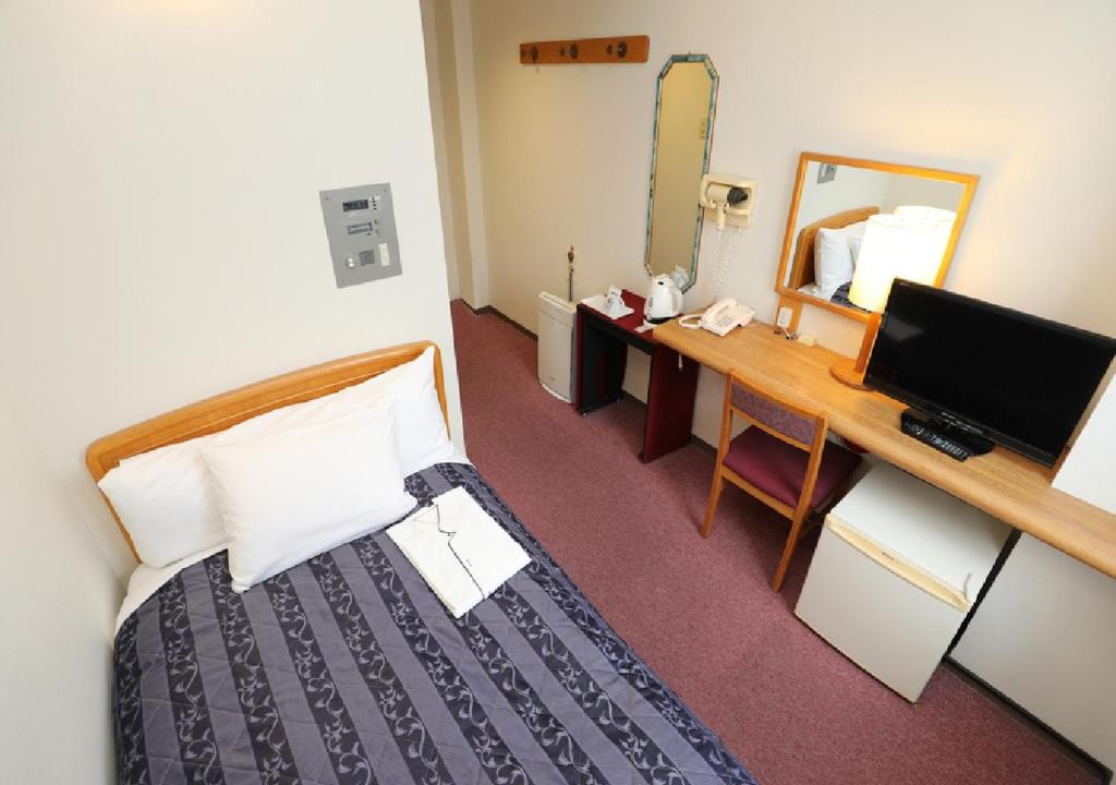 a hotel room with a bed and a desk and a mirror at Hotel Royal Garden Kisarazu / Vacation STAY 72210 in Kisarazu