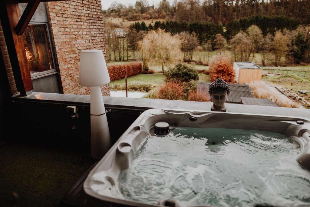 a bath tub in a yard with a lamp at At Home - Jacuzzi privatif in Gesves