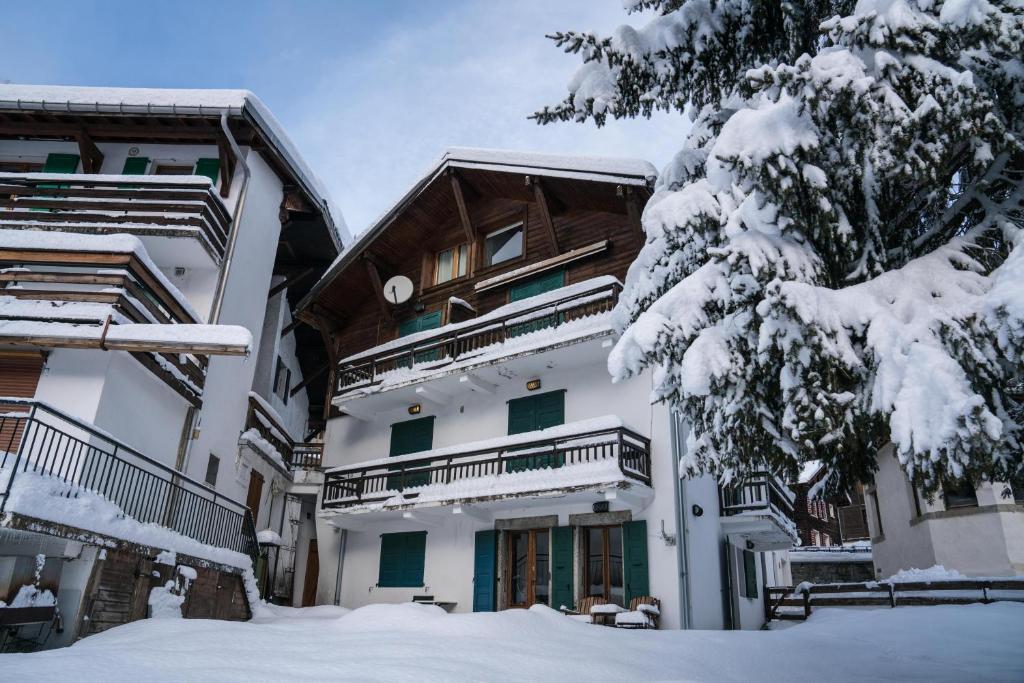 uma casa na neve com uma árvore em Prachtig familie appartement voor 6 personen in het hart van Argentière, Chamonix Mont-Blanc em Chamonix-Mont-Blanc
