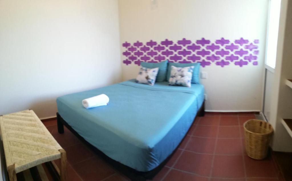 a bedroom with a blue bed with a purple headboard at Casa Puerto Bonito & Private Coworking in Puerto Escondido