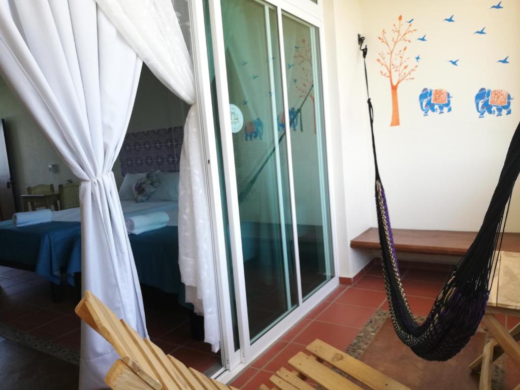 a room with a hammock and a bedroom at Casa Puerto Bonito & Private Coworking in Puerto Escondido