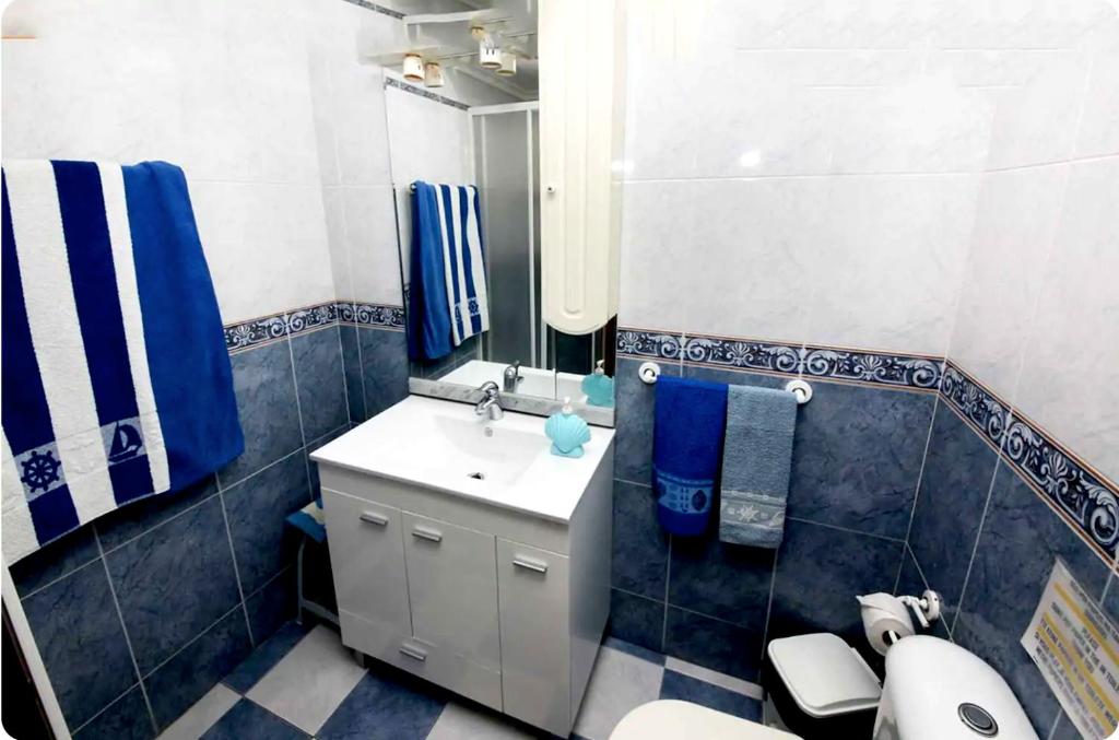 a bathroom with a sink and a toilet and a mirror at Beach House Above the Ocean AA3 in Ericeira