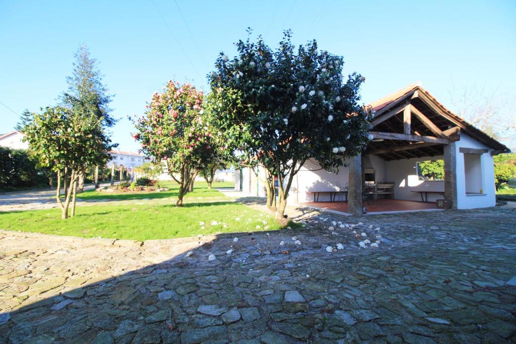 a house with a pavilion and trees in front of it at Casa dos Ouriços in Ponte de Lima