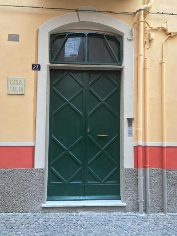 a green door on the side of a building at Casa Italia in Spotorno