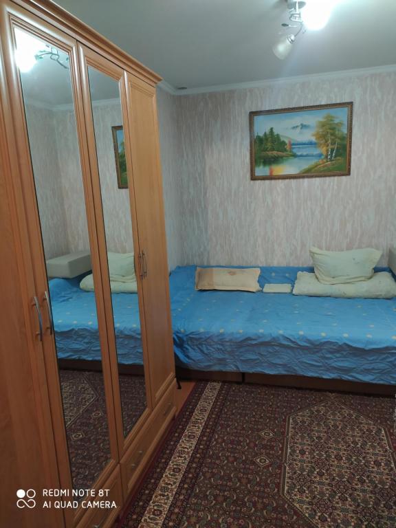 um pequeno quarto com uma cama e um espelho em HOME em Chisinau