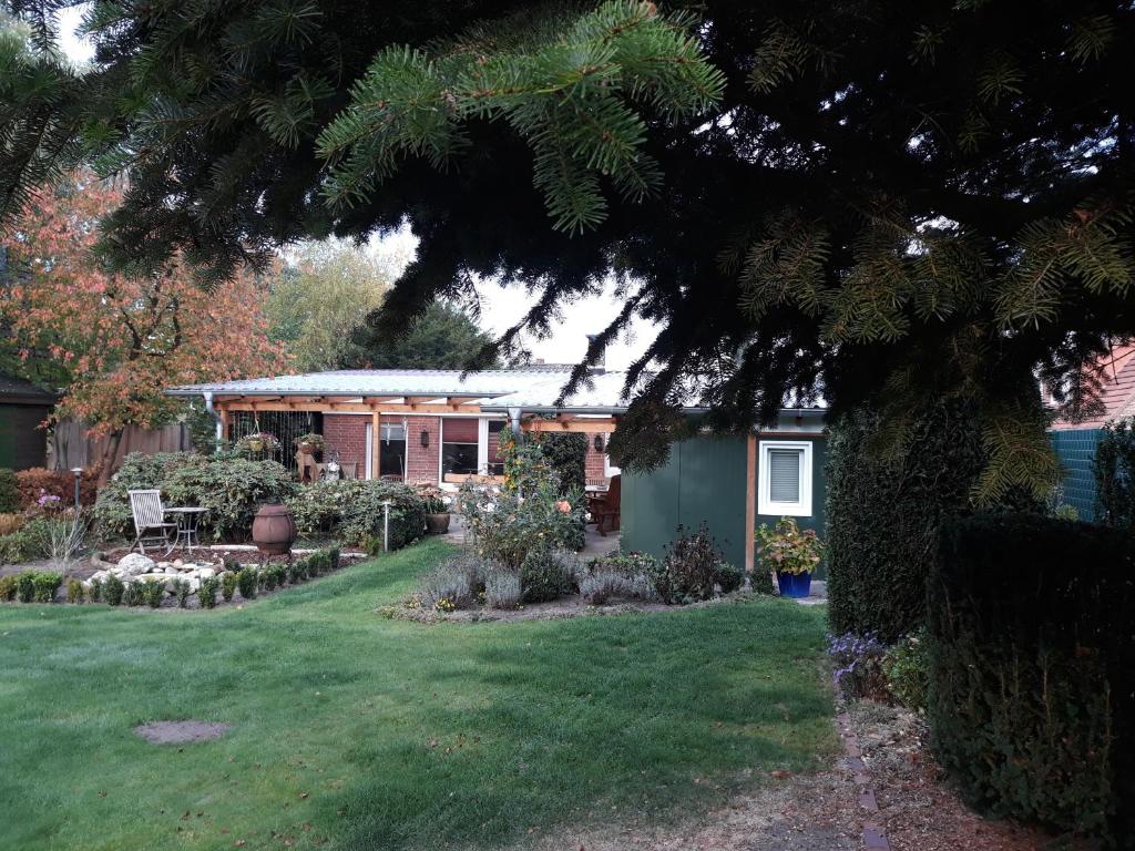 una casa con un jardín y un patio con un árbol en Haus Birkenheim, en Hatten