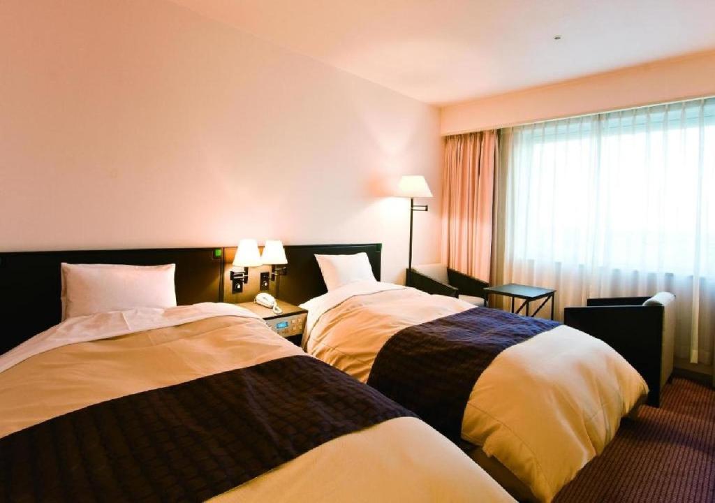 a hotel room with two beds and a window at Ogaki Forum Hotel / Vacation STAY 72182 in Ogaki
