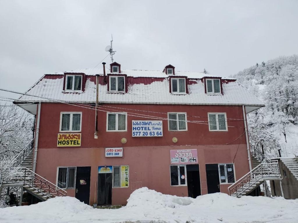 a large red building with snow in front of it at Hotel Toma in Khulo