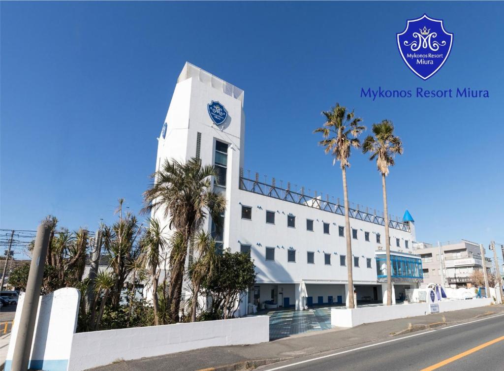 a white building with a clock tower with palm trees at Mykonos Resort Miura / Vacation STAY 72794 in Yokosuka