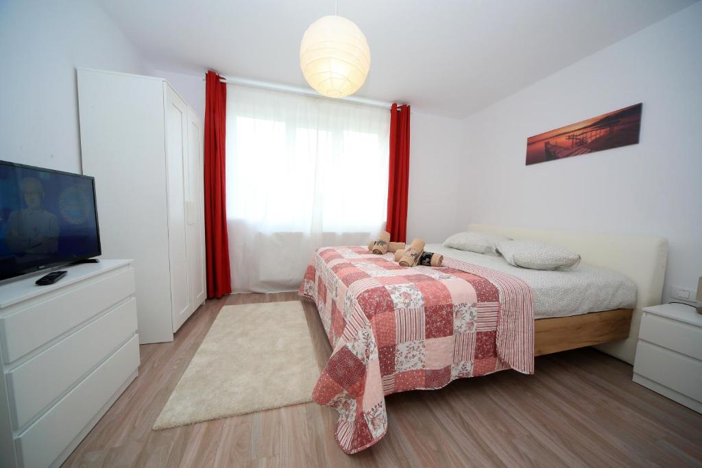 a bedroom with a bed with a blanket and a tv at Carpen View Residence in Săcele