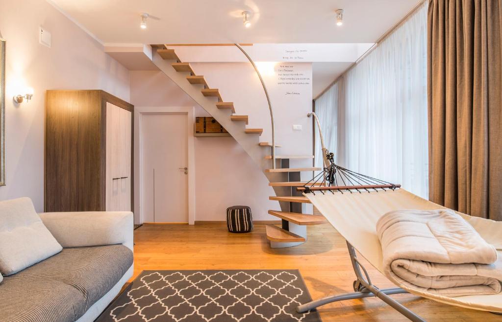 eine Wendeltreppe in einem Wohnzimmer mit einem Sofa in der Unterkunft Central 2-level Penthouse with Terrace and free parking in Riga
