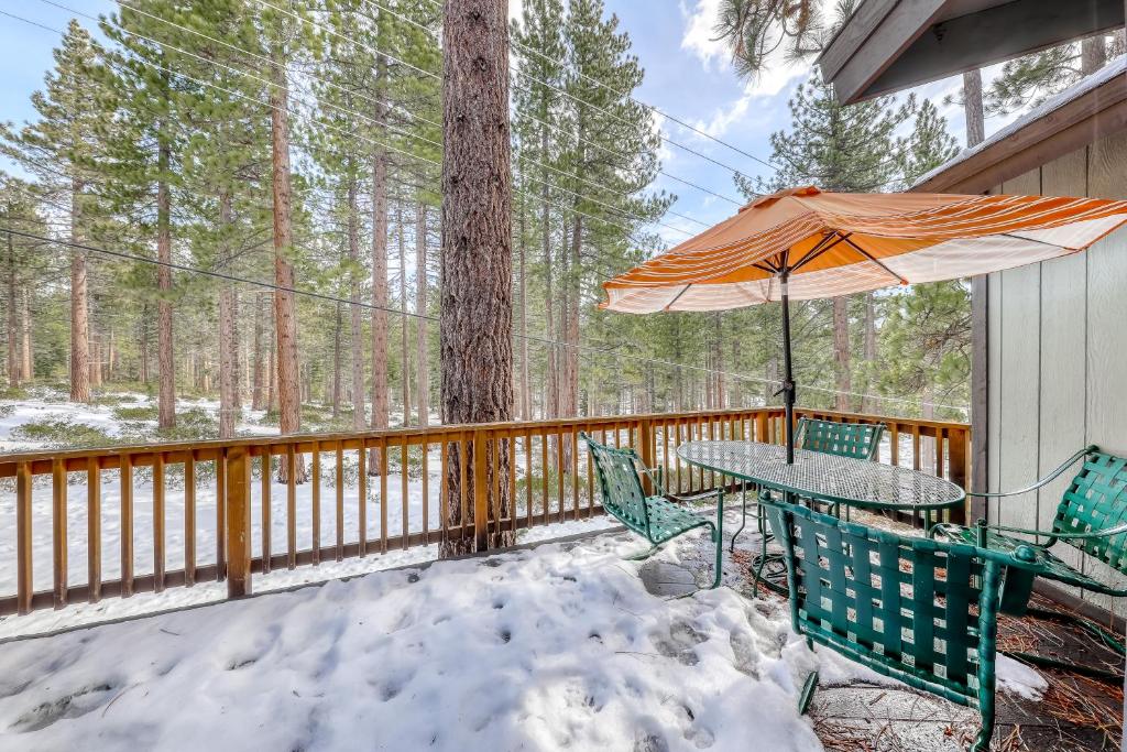 a table and chairs on a deck with an umbrella at Skyline Serenity in South Lake Tahoe