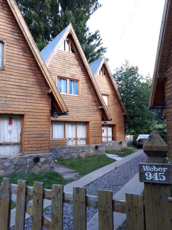 une maison en bois avec une clôture devant elle dans l'établissement Quiñehuen, à San Martín de los Andes