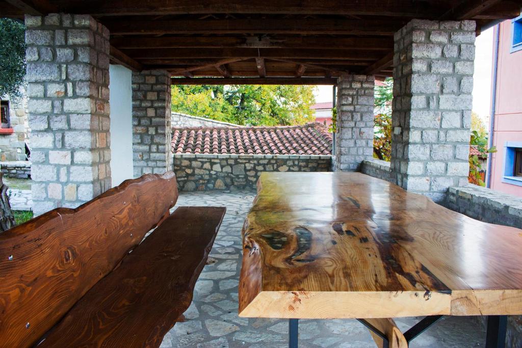 uma mesa de madeira e bancos num pátio em Santo Villaggio - Unique Villa em Trikala