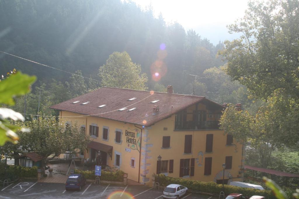 a large yellow building with a brown roof at Hotel Rural Bereau in Lesaka