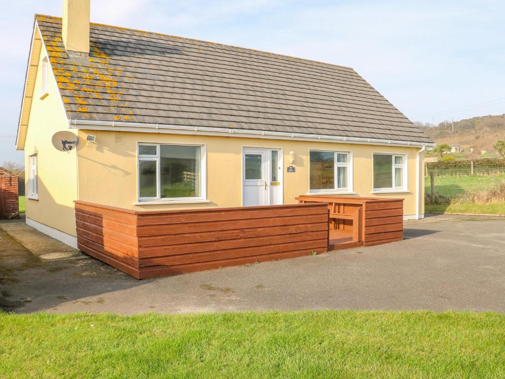 a small house with a wooden deck in front of it at The Trawler in Blackwater