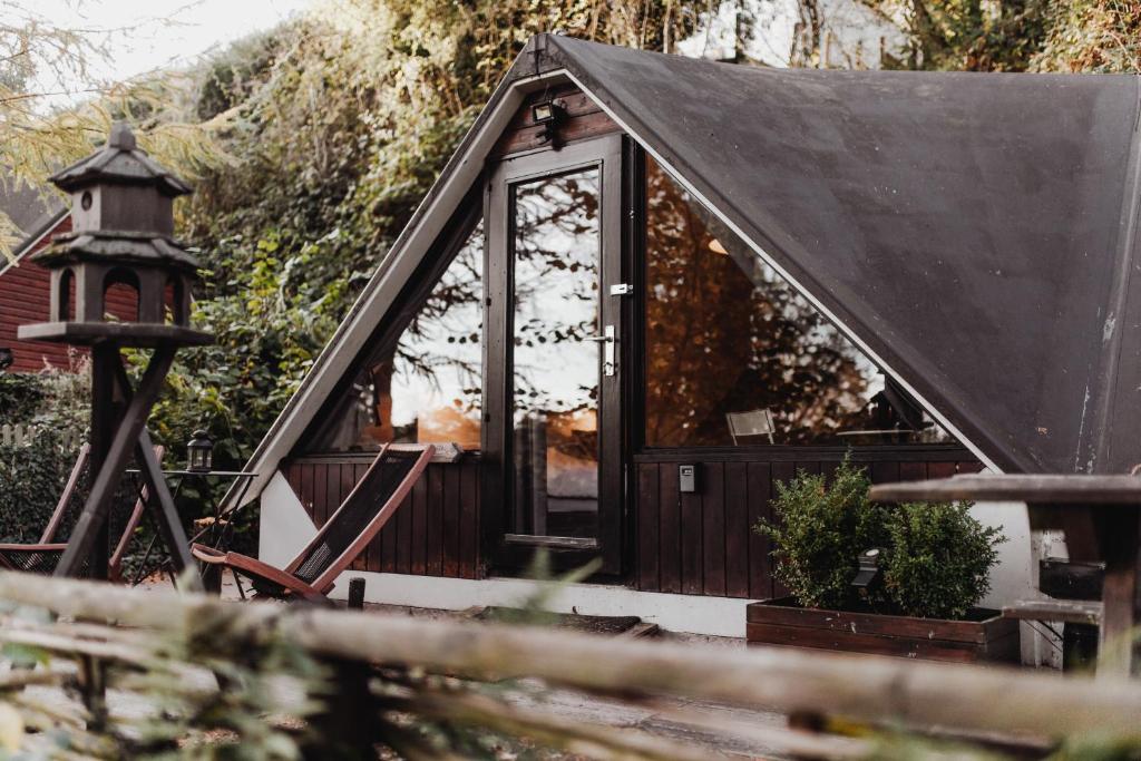 una pequeña casa con techo negro en Scandinave - In the Woods, en Gesves