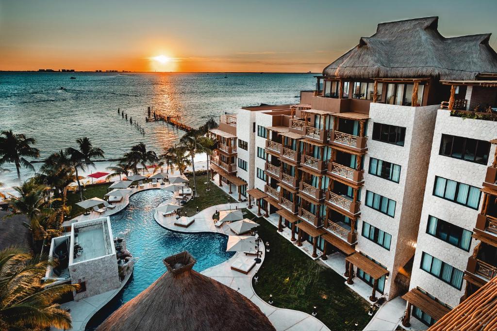 an aerial view of the resort and the ocean at sunset at Hotel Beló Isla Mujeres - All Inclusive - Sargassum Free in Isla Mujeres