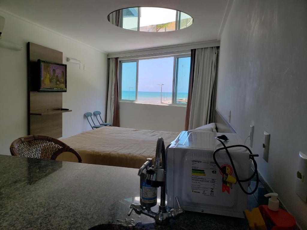 a room with a bedroom with a bed and a window at Flet Beira-mar, Blue Sucet in João Pessoa