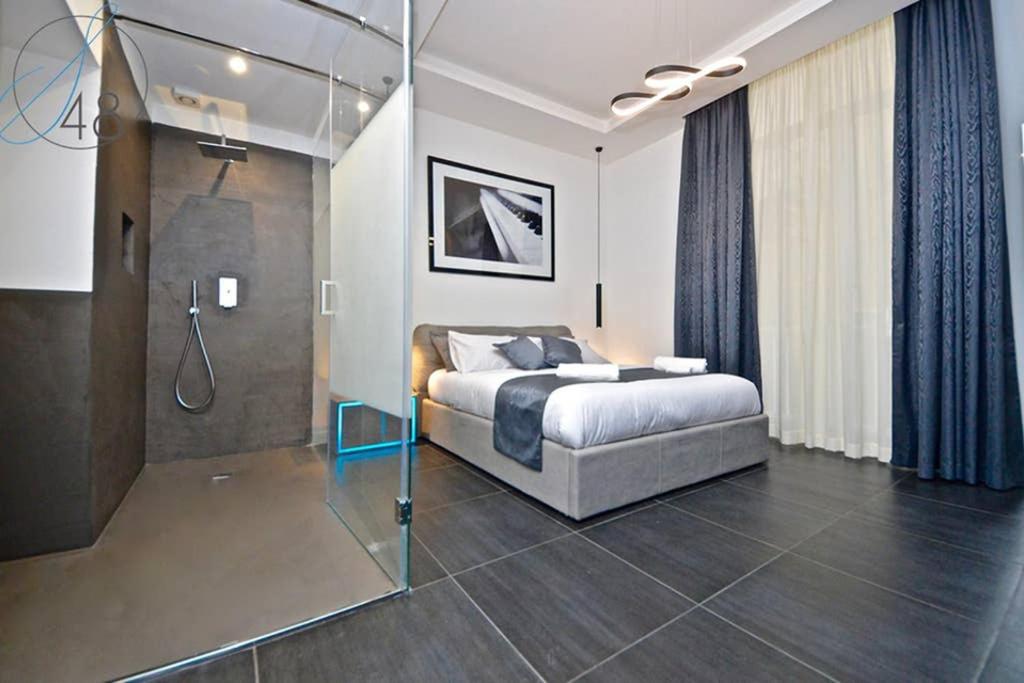 1 dormitorio con 1 cama y pared de cristal en Suite Quarantotto Luxury House, en Nápoles