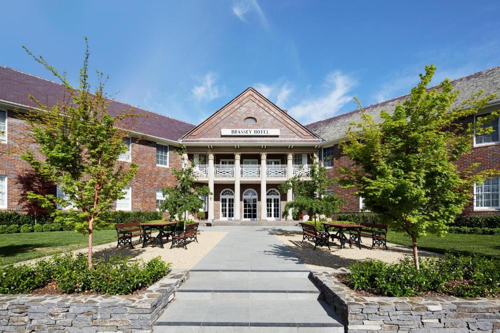 a large brick building with benches in front of it at Brassey Hotel - Managed by Doma Hotels in Canberra