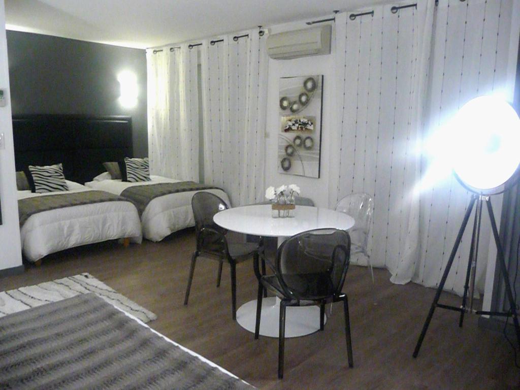 a room with a table and chairs and a bed at Hôtel Spunta Di Mare in Ajaccio