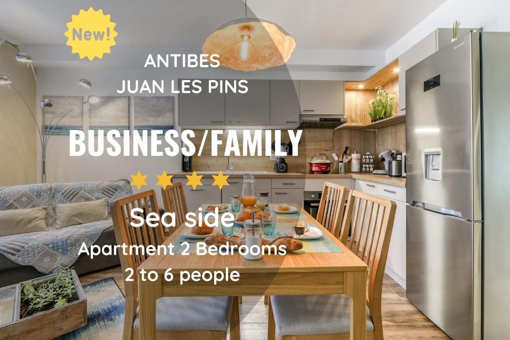 une cuisine avec une table en bois et un réfrigérateur dans l'établissement Le Vilmorin- Juan les Pins, à Antibes