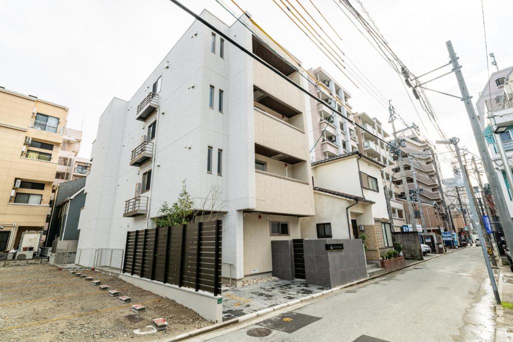 ein weißes Gebäude an der Straßenseite in der Unterkunft GRAND BASE Haruyoshi in Fukuoka
