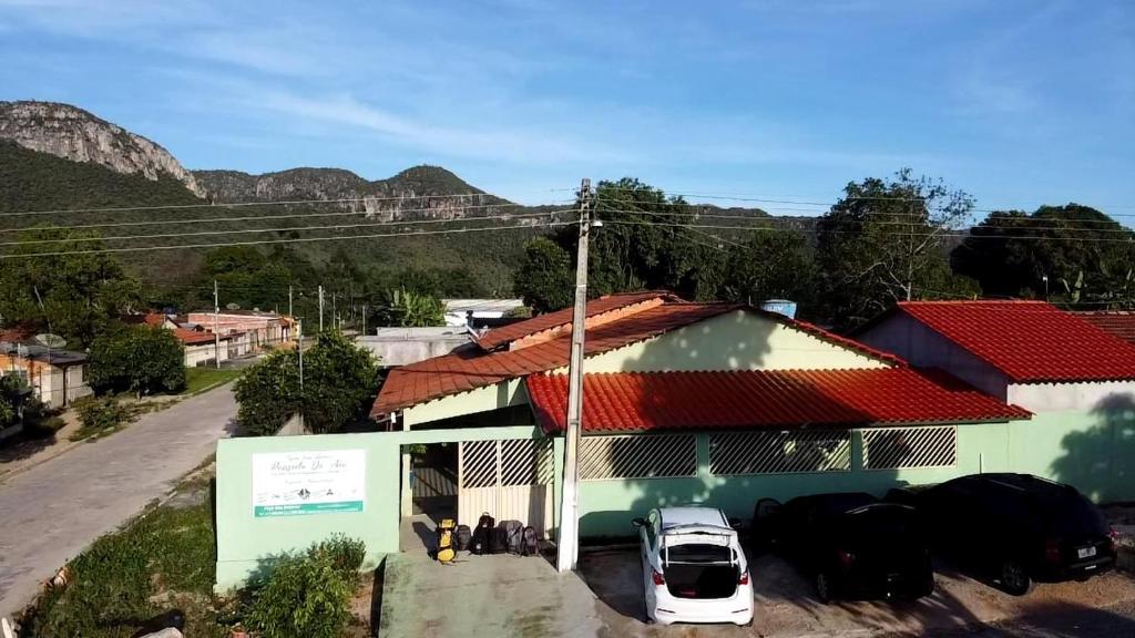 une voiture garée à l'extérieur d'un bâtiment avec des montagnes en arrière-plan dans l'établissement Pousada da Ana, à Cavalcante