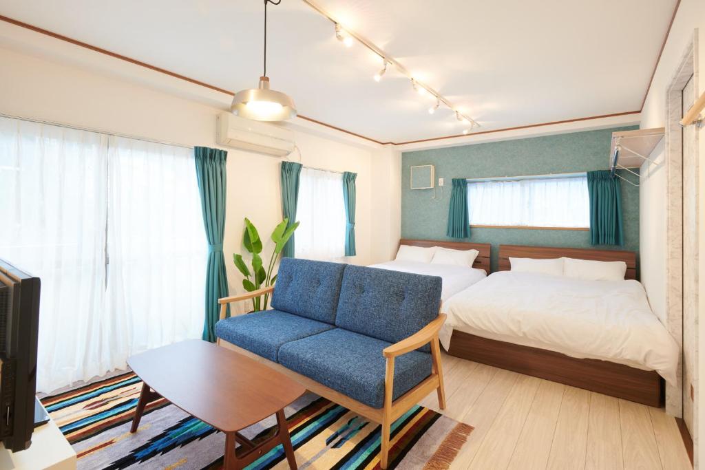 a bedroom with a bed and a blue chair at Awaji Portside Holiday Home CHOUTA - Self Check-In Only in Akashi