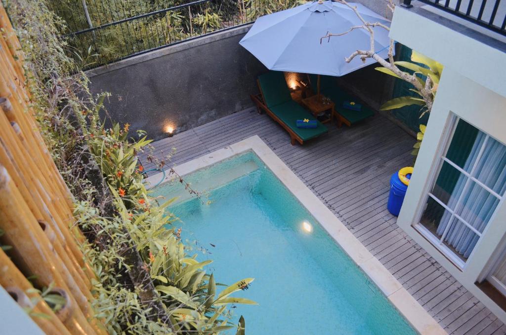 an overhead view of a swimming pool with an umbrella at The Green Home Bali in Denpasar