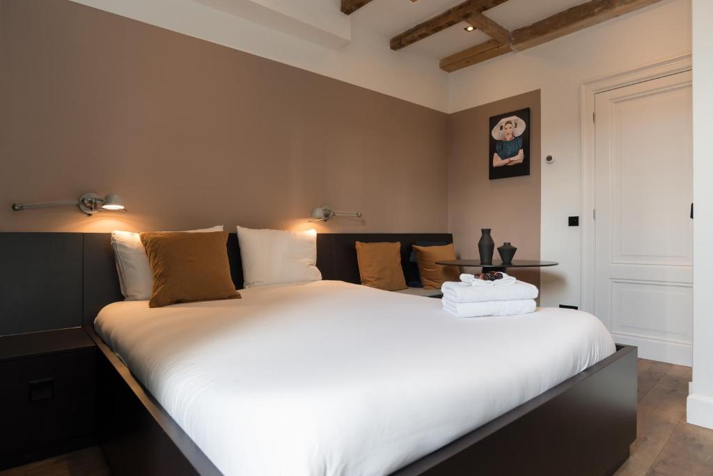 a bedroom with a large bed with white sheets at City centre studio canal belt in Amsterdam