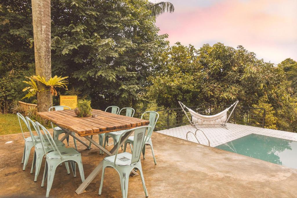 a wooden table and chairs next to a pool at Villa Jenis By The Villas 100 in Bogor