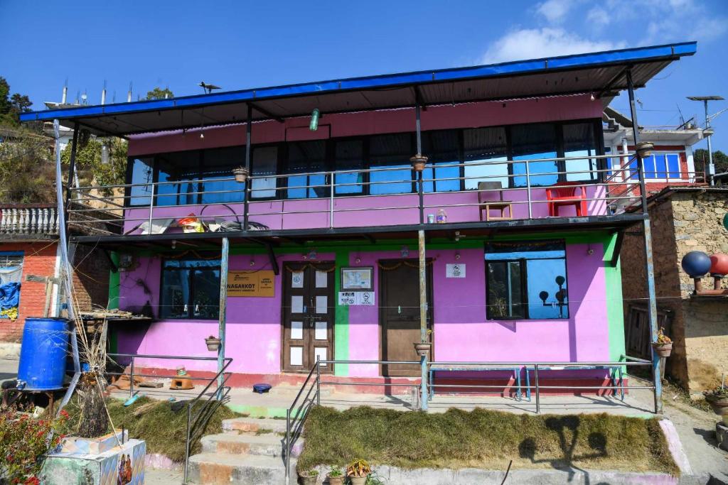 una casa rosa con balcón en la parte superior en Homestay in Nagarkot en Thimi