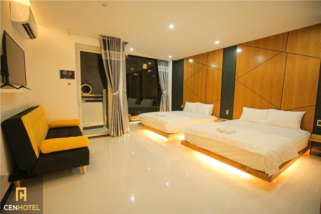 een slaapkamer met 2 bedden en een stoel. bij Cen Hotel in Vung Tau